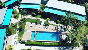 An aerial view of a resort with multiple buildings, a swimming pool, and palm trees. - Tum Mai Kaew Lanta Resort (Ko Lanta)