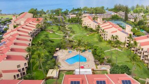 A resort with multiple buildings, a central pool, and a view of the ocean. - Walk to Beach | Pools, Pickleball, Kihei (Kihei)