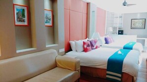 Une chambre d’hôtel avec un canapé, deux lits et une grande fenêtre.