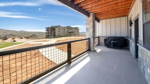 A balcony with a view of a building and a covered area. - Retreat at Jordanelle | Relaxing w/ Lake Views (Heber City)