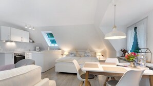 A modern loft-style bedroom with a skylight, a kitchenette, and a dining area. - Studio Apartment 'Appartement Skagen' with Shared Garden and Wi-Fi (Glücksburg (Ostsee))
