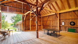 A spacious barn with a ping pong table, a dartboard, and a green chalkboard. - Apartment 'Ferienwohnung Marie' with Shared Terrace, Shared Garden and Wi-Fi (Egling)