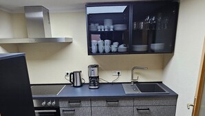 A compact kitchen with a built-in stove, a coffee maker, and a microwave.