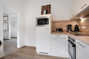 A modern kitchen with a microwave, coffee maker, and oven. - Apartment 'Ferienwohnung Finsterwalde 2' with Wi-Fi (Finsterwalde)
