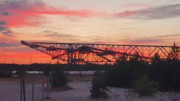 Een groot industrieel gebouw, mogelijk een brug of kraan, met een woestijnlandschap op de voorgrond.