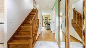 A wooden staircase leading to a dining area with chairs and a table.