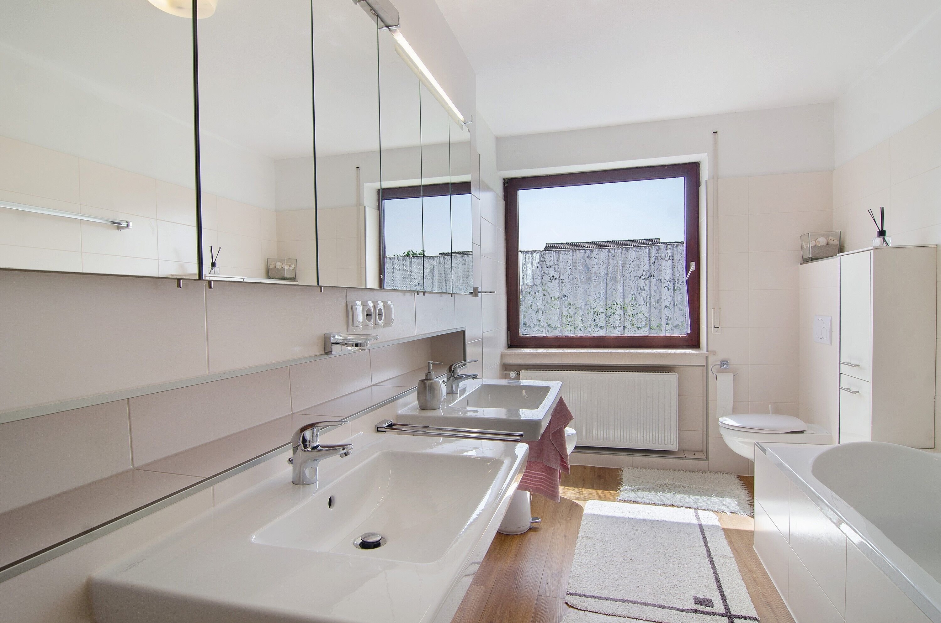 Un bagno moderno con due lavandini, un water e una vasca da bagno.