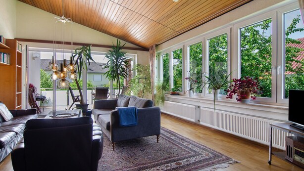 A spacious living room with a wooden ceiling, large windows, and a variety of furniture including a sofa, armchair, and a coffee table. - Holiday Home 'Ferienhaus Christine lake constance north' with Private Terrace and Private Garden (Pfullendorf)