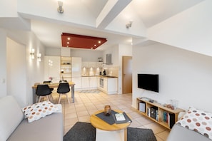 Un appartement moderne comprenant un coin repas, une cuisine et un salon.