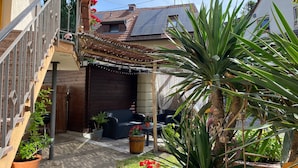 Un quartier résidentiel agrémenté d’un escalier, de plantes en pot, de mobilier d’extérieur et d’un petit jardin.