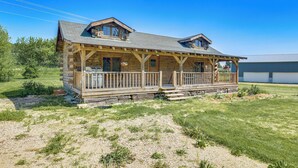 A log cabin with a porch, two dormer windows, and a covered deck. - Bellevue Log Cabin w/ Gas Grill & Creek Access (Bellevue)