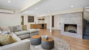 Un salon spacieux avec une cheminée, un canapé et une table basse.