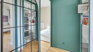 A room with a bed, a white wall, and a teal door. - 705 Suite Lecourbette - Superb apartment (Paris 15 Vaugirard)