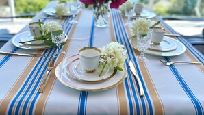 A table set for a meal with a view of a lake and mountains in the background. - Blue House (Gibsons)