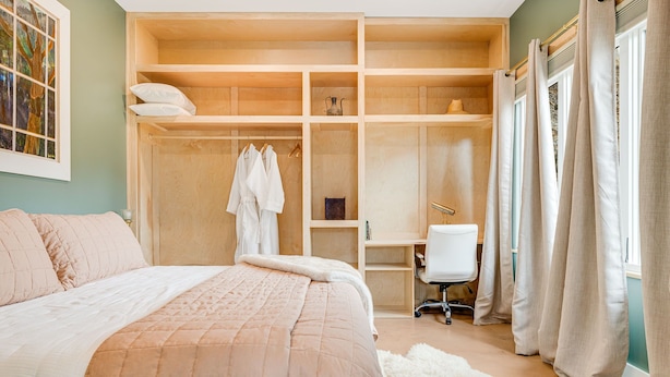 Une chambre à coucher avec un grand lit, une armoire, un bureau et une chaise.