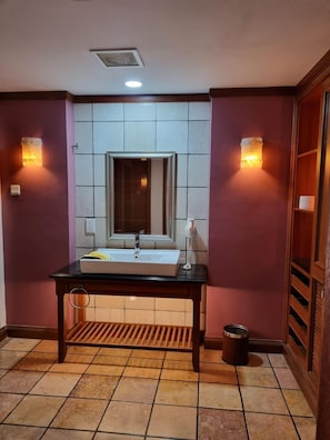 Ein Badezimmer mit Waschbecken, Spiegel und zwei Wandleuchten.