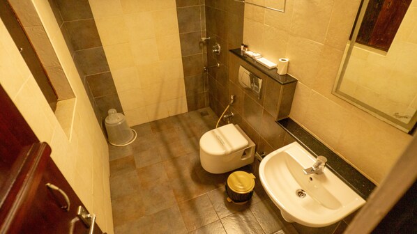 A compact bathroom with a toilet, sink, and shower. - Kumarakom Heritage (Vaikom)