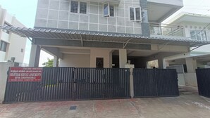 Een omheind toegangspunt naar Shantham Service Apartments, met een bord waarop contactgegevens en locatie staan.