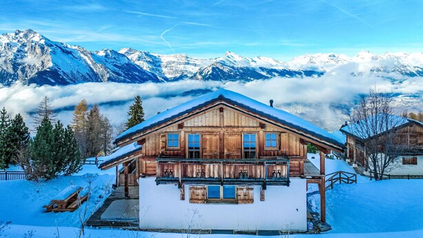 A wooden chalet with a balcony, surrounded by snow-covered mountains and a clear sky. - Gingembre 12 by Interhome (Nendaz)