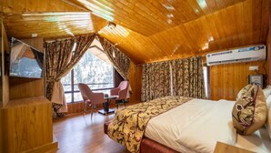 Una habitación acogedora con una cama, un escritorio y un televisor.