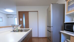 Een moderne keuken met een roestvrijstalen koelkast, een magnetron en een gootsteen met een kraan.
