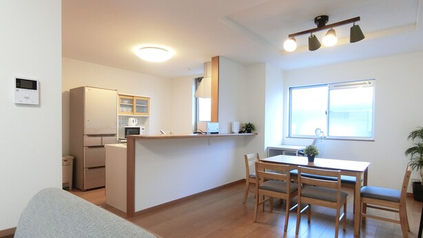 Een functionele leefruimte met kitchenette, eethoek en zithoek.