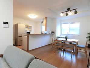 A compact living space with a kitchenette, a dining area, and a seating area. - eRapos House Imamiya (Osaka)