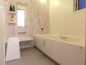 A modern bathroom with a white sink, toilet, and bathtub. There are shelves with toiletries and a mirror above the sink.
