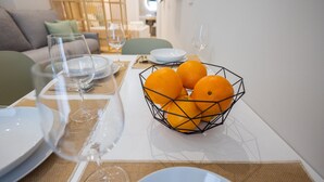 Ein Esstisch mit Tellern, Gläsern und einem Drahtkorb mit Orangen.
