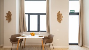Un coin repas comprenant une table, des chaises et une fenêtre avec des rideaux.