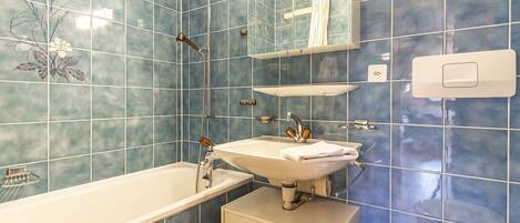 A bathroom with a bathtub, sink, and toilet.