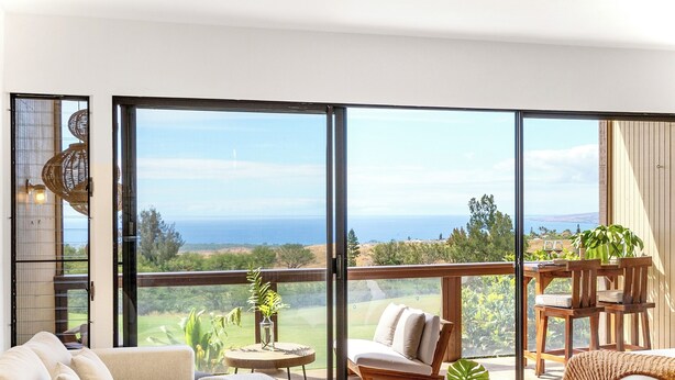 A spacious living area with a large sliding glass door leading to a balcony with a scenic view. - NEW- Expansive Ocean View- Pool/Tennis/Pickleball (Waikoloa Village)