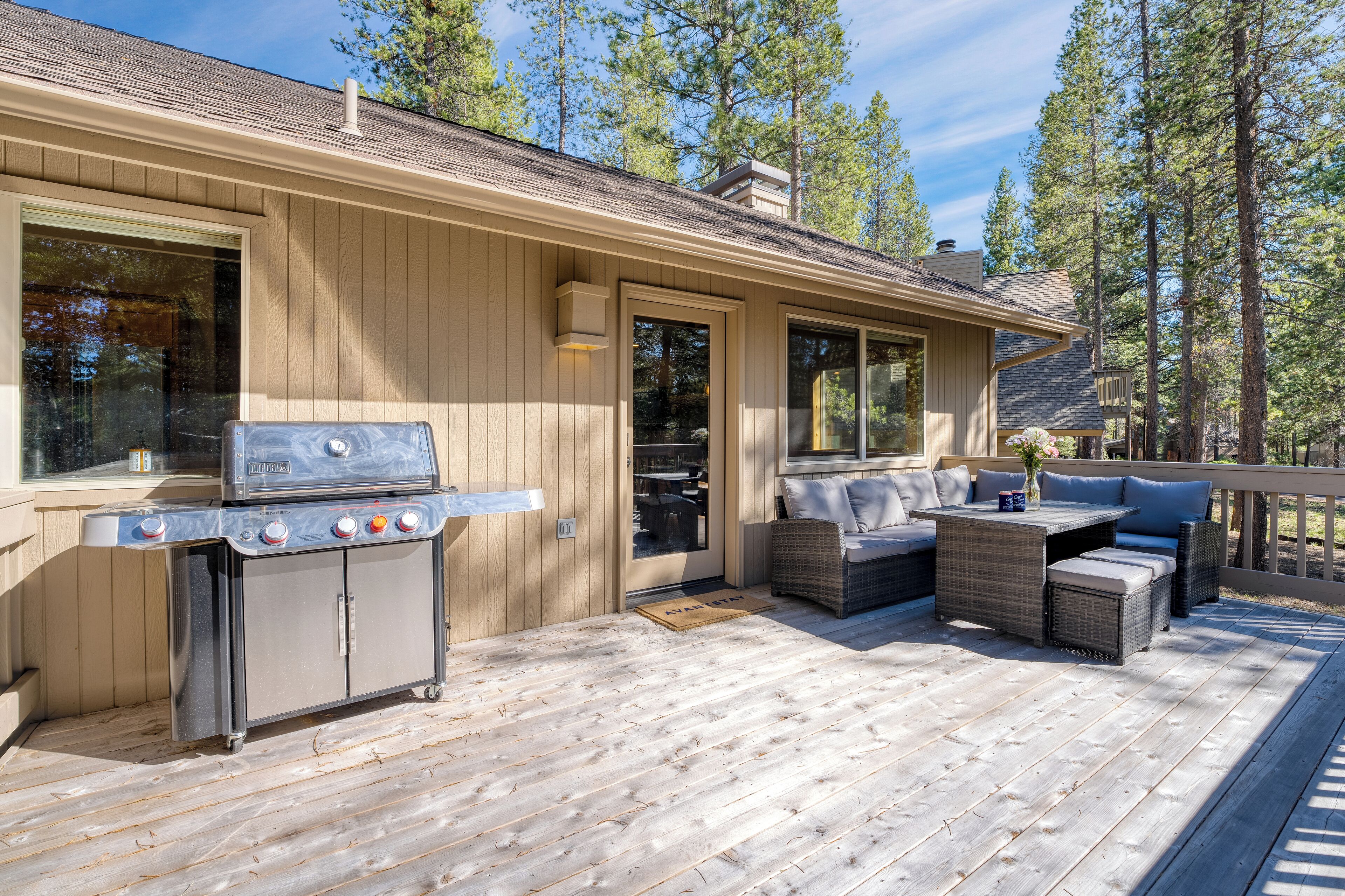 A wooden deck with a grill and outdoor furniture.