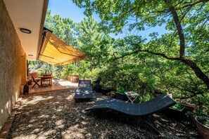 An outdoor patio area with a hammock, seating, and a table under a canopy. - Agréable Havres de Paix à Roussillon (Roussillon)