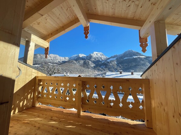 Ein Holzbalkon mit Blick auf schneebedeckte Berge.