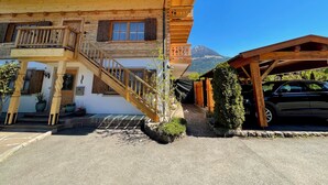 A wooden building with a staircase, a balcony, and a mountain in the background. - Ferienwohnung, 1-2 Personen, 86 qm, Separates Schlafzimmer, Küche, Wohnzimmer, Du/wc, Balkon (Schönau am Königssee)