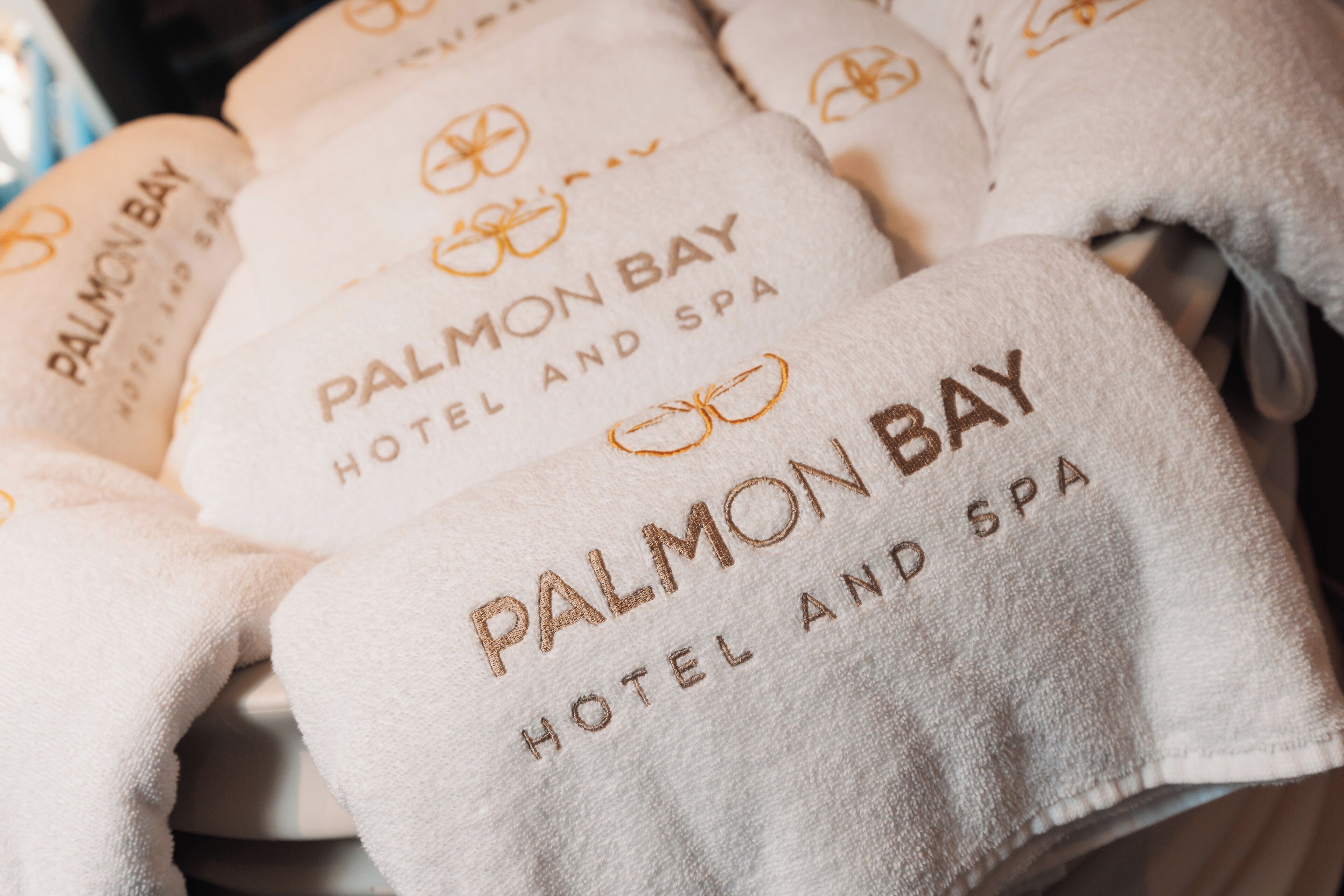 A stack of towels with the text "PALMON BAY HOTEL AND SPA".