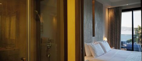 Ein Hotelzimmer mit Bett, Dusche und Meerblick.
