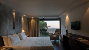 A modern hotel room with a large bed, a desk, a chair, and a TV. - Palmon Bay Hotel & Spa (Igalo)