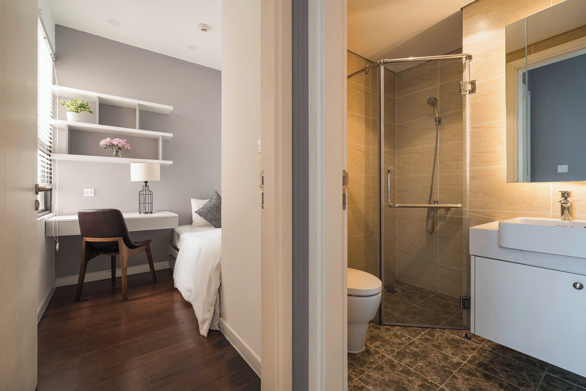 A modern bathroom with a shower, toilet, and a vanity with a mirror.