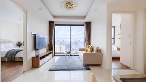 A modern hotel room with a large balcony, a sofa, a TV, and a dining area. - Mira Housing- Vinhomes D'Capitale  (Hanoi)