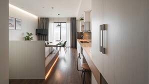 A modern kitchen with a dining area, wooden flooring, and a view of the outdoors. - Mira Housing- Vinhomes D'Capitale  (Hanoi)