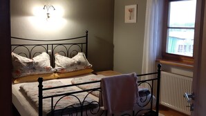 Ein Schlafzimmer mit einem Bett, einem Fenster und einer Heizung.