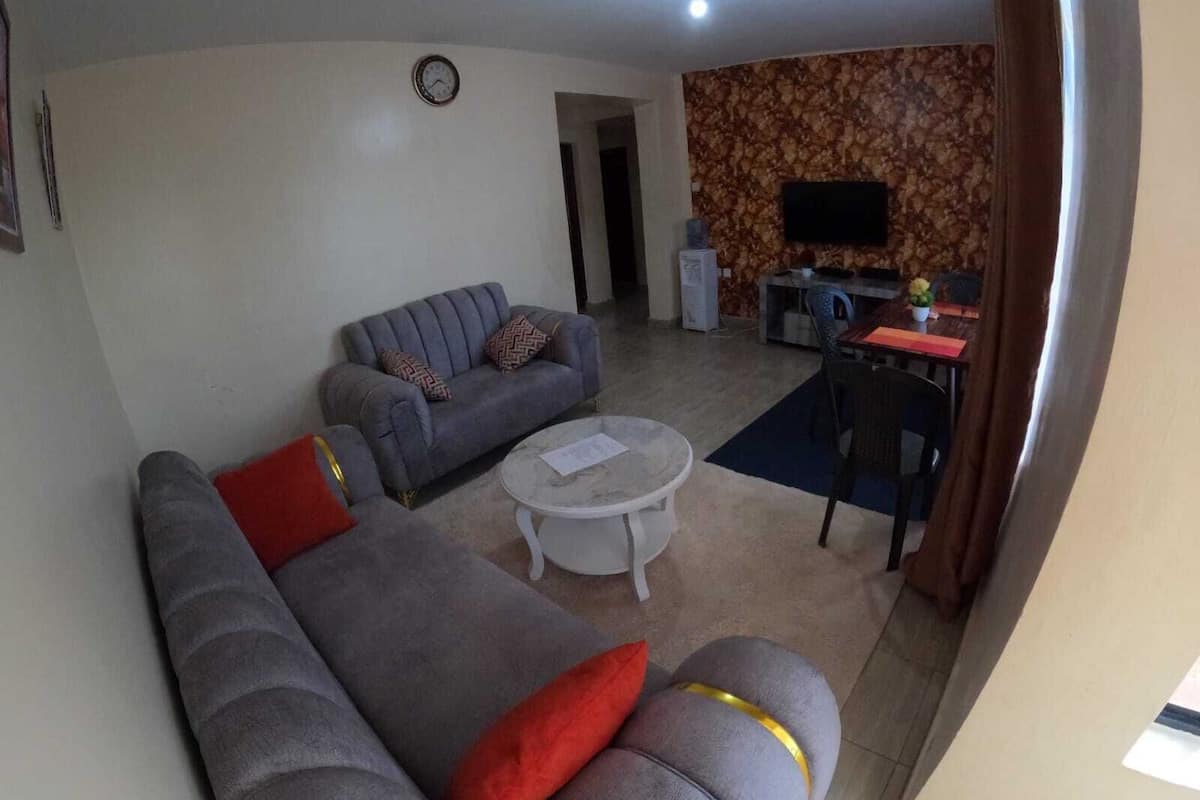 Un salon avec un canapé, une table basse et un téléviseur.
