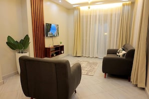 Apartamento luxo, 1 quarto | Área de estar | TV de tela plana