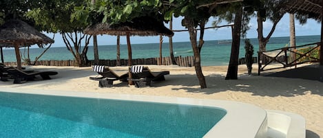 Una piscina al aire libre, sombrillas, tumbonas