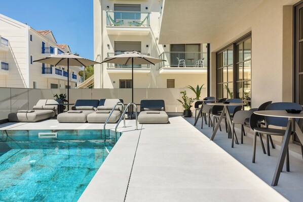 Seasonal outdoor pool, open 11:00 AM to 7:00 PM, pool umbrellas