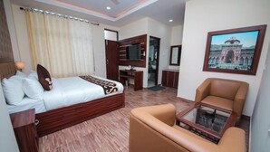 A hotel room with a bed, a sofa, a TV, a mirror, and a framed picture on the wall. - Amritara Social Palace (Chinyalisaur)