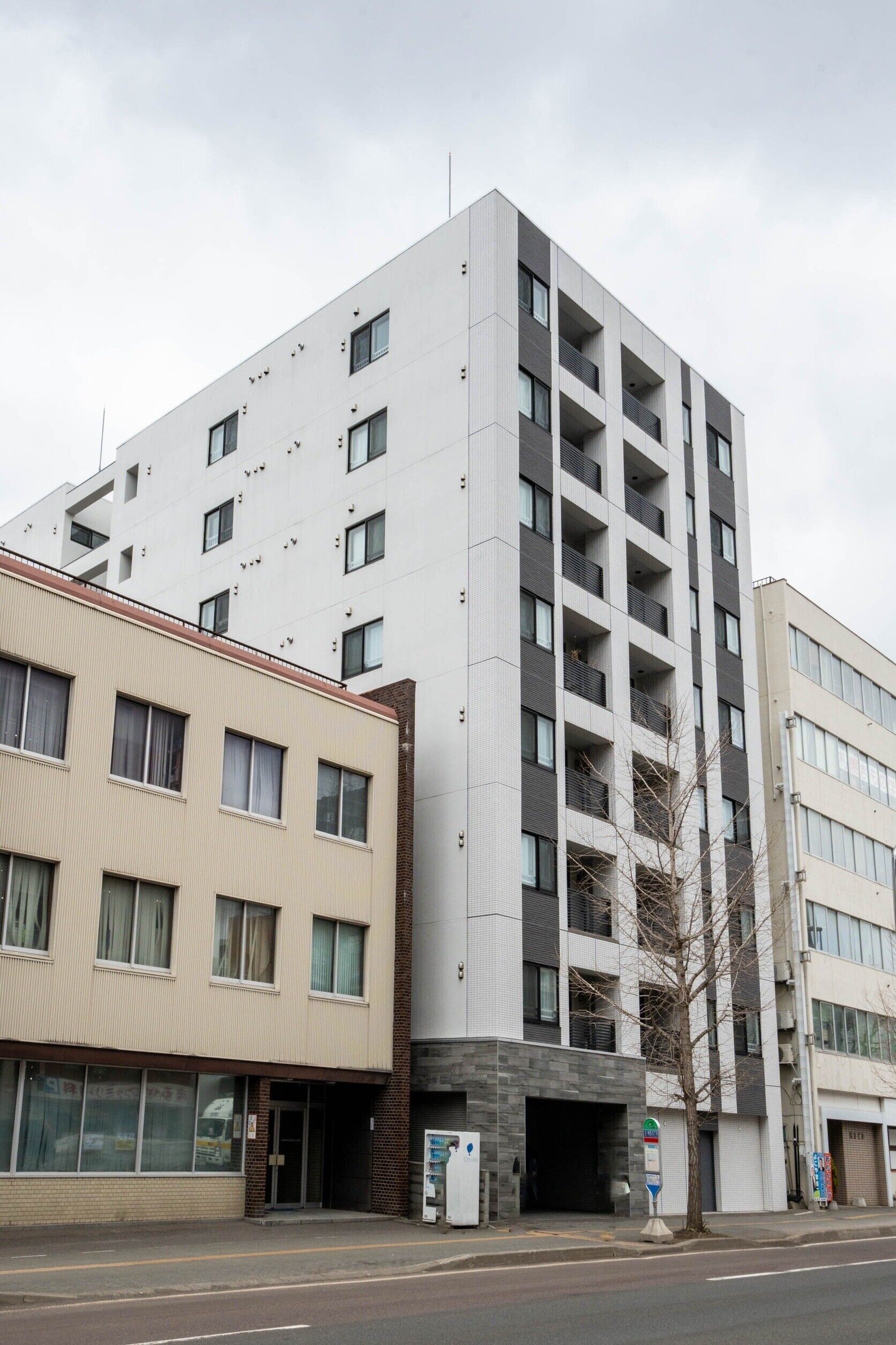 A multi-story building with a modern architectural design, featuring a mix of balconies and windows.
