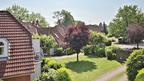 Un quartiere residenziale con case, un prato curato e un cancello.